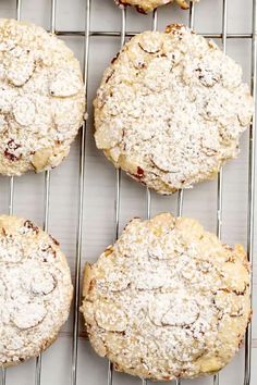 four cookies with powdered sugar on top sit on a cooling rack