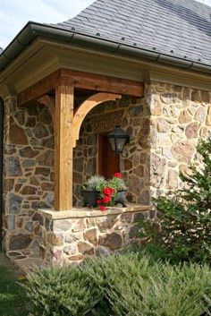 a small stone building with a wooden porch