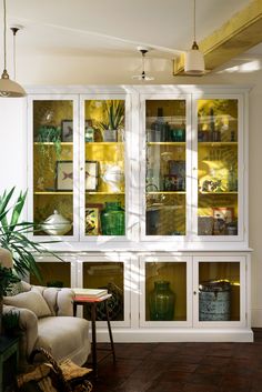 a living room filled with furniture and lots of green glass doors on the windowsill