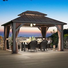 a gazebo sitting on top of a wooden deck next to a table and chairs