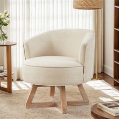 a white chair sitting on top of a rug in a living room next to a book shelf