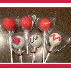 four red and white lollipops wrapped in cellophane on a counter