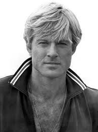 a black and white photo of a man with blonde hair wearing a adidas jacket