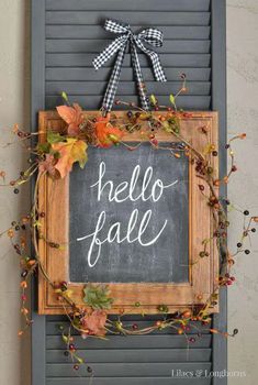 a sign that says hello fall hanging on the side of a door with leaves around it