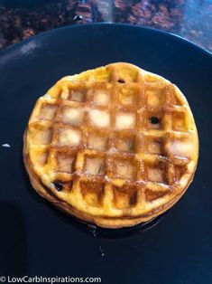 a waffle sitting on top of a black plate