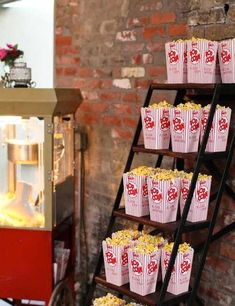 an old fashioned popcorn vending machine with red and white paper cups