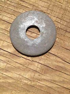 a metal ring sitting on top of a wooden table next to a piece of wood