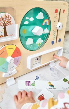 a young child playing with a wooden toy clock and matching cards in front of it