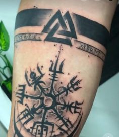 a black and white tattoo on the leg of a person with a compass in it