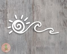 an image of the sun and waves cut out of paper on a wooden surface with a sticker