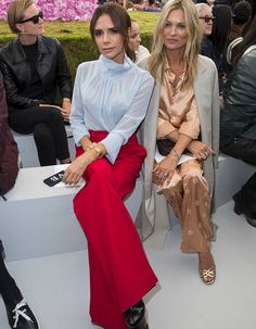 two women sitting next to each other at a fashion show