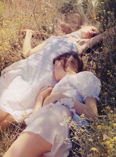 two women laying down in the grass