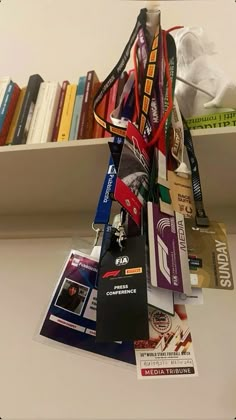 a book shelf filled with lots of books next to a pile of luggage tags and lanyards