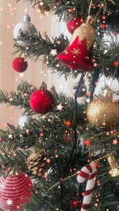 the christmas tree is decorated with red and gold ornaments, candy canes, and stars