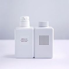 two white plastic bottles sitting next to each other