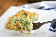 broccoli casserole on a white plate with a fork