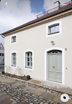 a white house with green doors and windows