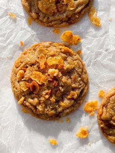 three cookies on top of white paper with orange peels