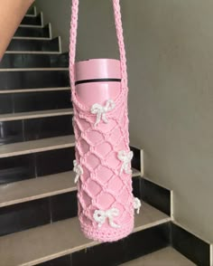 a pink handbag hanging from the side of some stairs