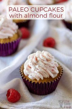 some cupcakes with white frosting and raspberries on the top one