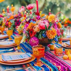 a colorful table setting with candles and flowers