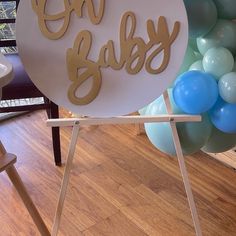 there is a sign that says oh baby on it and some balloons in the background