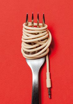 a close up of a fork with wires attached to it on a red table top