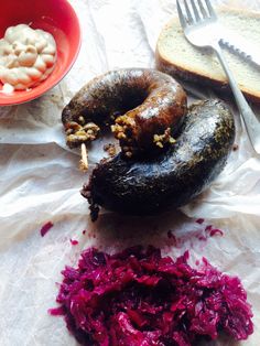 an assortment of food including bread, red cabbage and other foodstuffs are on the table