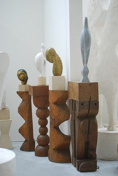 several wooden sculptures sitting on top of a white floor