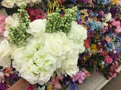 a bunch of flowers that are sitting on a table in front of some kind of wall