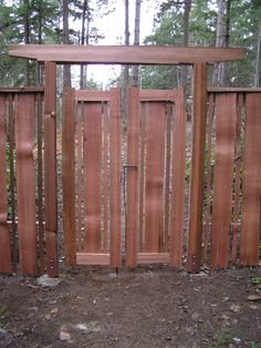 an open wooden gate in the woods