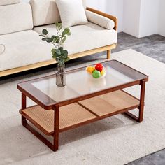 a living room with a couch, coffee table and vase on the floor in front of it