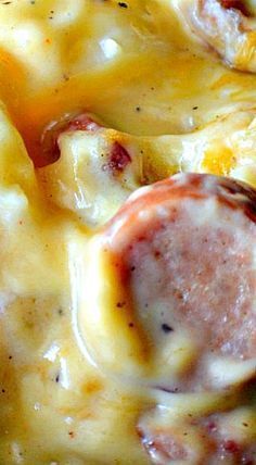 a close up of a plate of food with sausage and cheese on it's surface