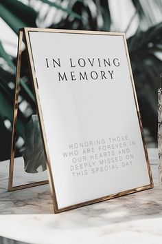 there is a sign that says in loving memory next to a vase with flowers on it