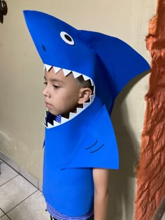 a young boy wearing a blue shark costume