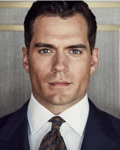 a man in a suit and tie looking at the camera with an intense look on his face