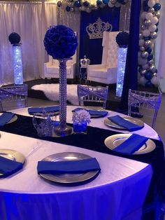 a table set up with blue and silver decorations