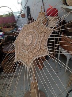 an umbrella made out of sticks in a room with other items on the floor and tables