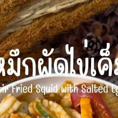 an advertisement for fried squid with salted eggs in thai writing on the front cover