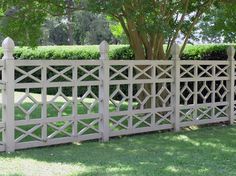 a white picket fence in front of a tree