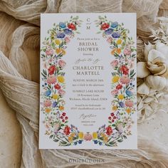 the wedding stationery is surrounded by flowers