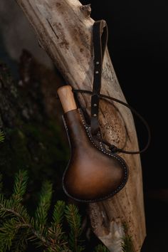 a leather boot hanging from a tree branch