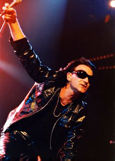 a man with sunglasses on holding a microphone