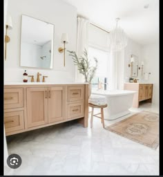 a large bathroom with two sinks and a bathtub in the middle of the room