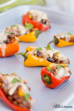 mini stuffed peppers with meat and cheese on a baking sheet, ready to be cooked