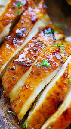 sliced chicken with sauce and green onions on a cutting board