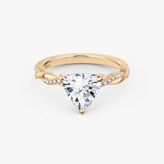 a yellow gold engagement ring with a pear shaped diamond on the top and side stones