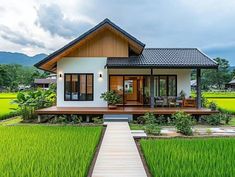 a small house sitting on top of a lush green field next to a wooden walkway