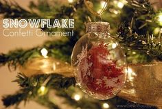 a glass ornament hanging from a christmas tree with snowflake on it