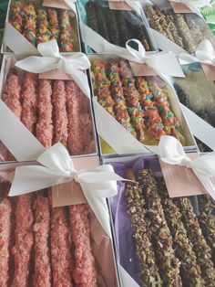 there are many different types of donuts in the boxes on this table, each with a ribbon